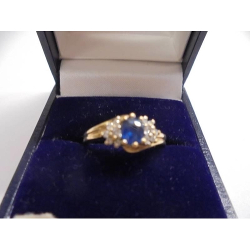 1020 - An un-marked yellow metal ring set central sapphire and diamonds, size K, 2.31 grams.