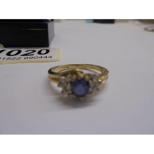 1020 - An un-marked yellow metal ring set central sapphire and diamonds, size K, 2.31 grams.