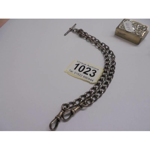 1023 - A silver watch chain, a silver heart shaped vesta case and a silver match box holder,