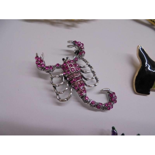 1027 - Eight good quality fashion brooches including peacock, snakes, dog etc.,