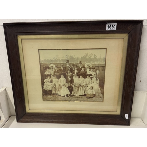 1630 - A large oak framed Edwardian sepia photograph of a wedding group