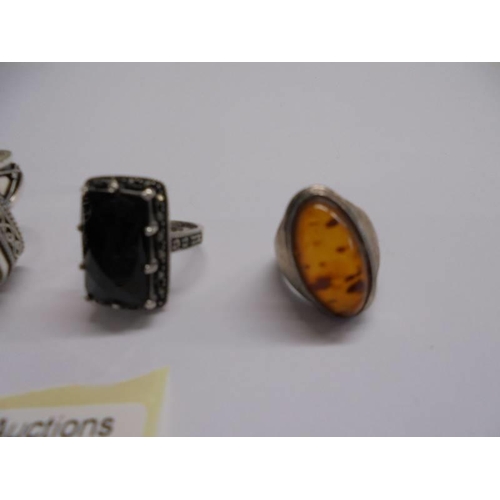 1043 - A silver ring set amber, two other silver rings and a yellow metal and pearl ring.