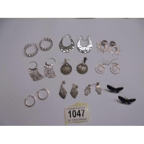 1047 - Ten pairs of white metal fashion earrings.