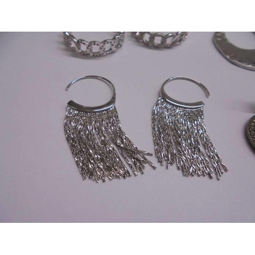 1047 - Ten pairs of white metal fashion earrings.