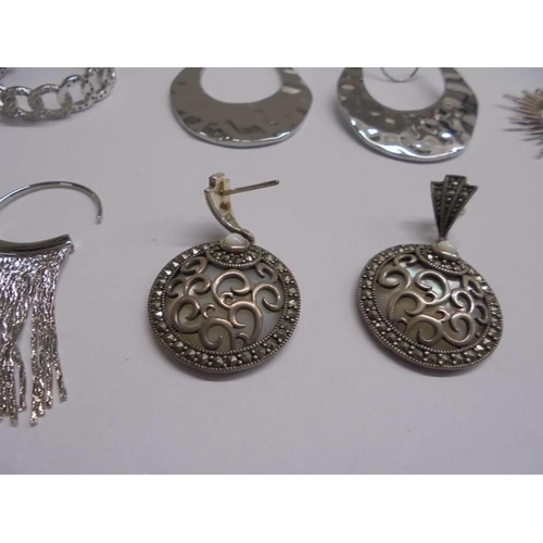 1047 - Ten pairs of white metal fashion earrings.