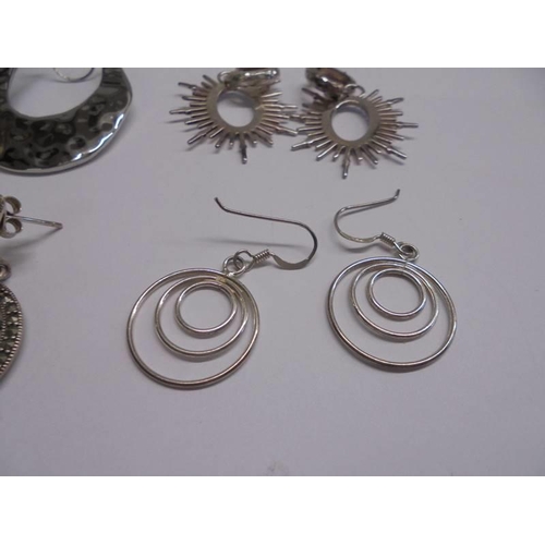 1047 - Ten pairs of white metal fashion earrings.