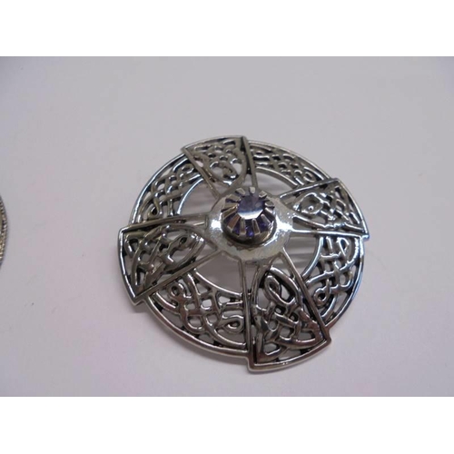 1049 - A silver and mother of pearl brooch (Jerusalem), a Celtic style brooch and a brooch marked Scotland.