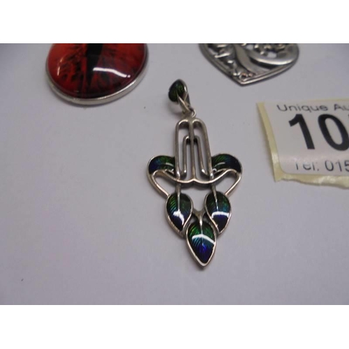 1054 - A silver art nouveau style pendant and two others.