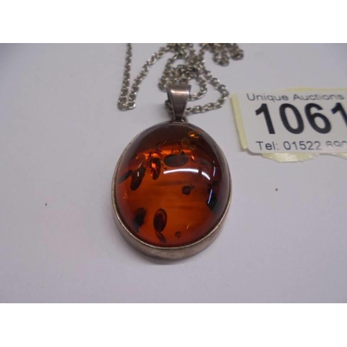 1061 - A silver pendant set amber.