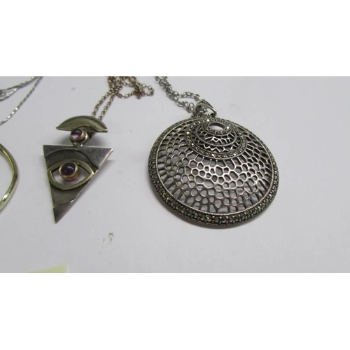 1067 - Four assorted white metal fashion pendants.