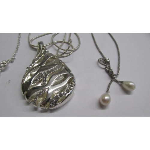 1068 - Three assorted white metal fashion pendants and a necklace.