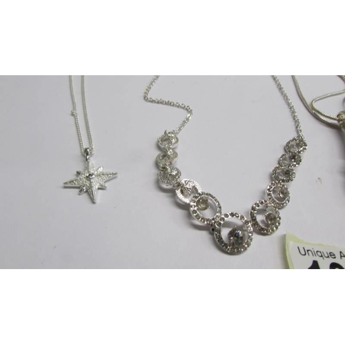 1068 - Three assorted white metal fashion pendants and a necklace.