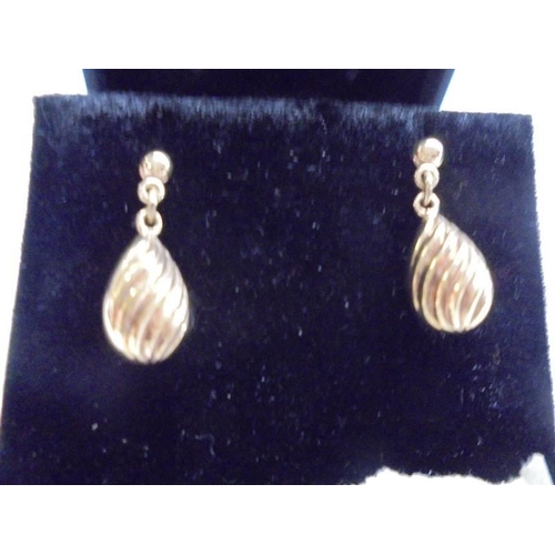 1138 - A pair of 9ct gold pendant earrings in a swirl design. 1.68 grams.