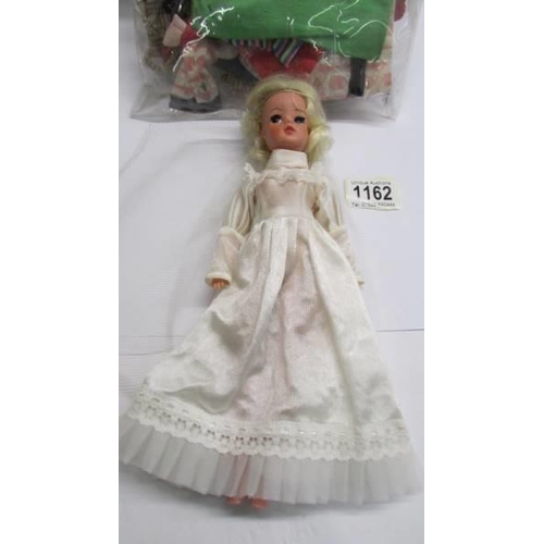 1162 - A Sindy doll in wedding dress and a quantity of vintage Sindy clothes.