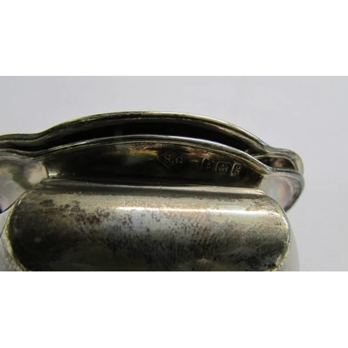 1170 - A silver mustard pot with a white metal spoon.