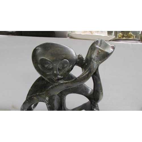 1201 - An unusual abstract African soapstone figure of a man playing an instrument.