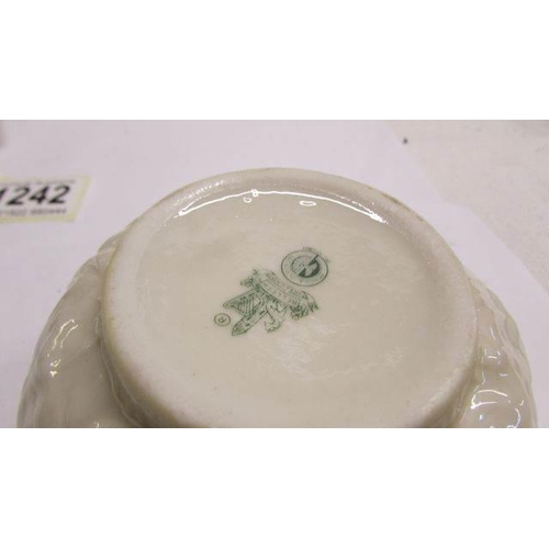 1242 - A Belleek butter dish in the form of a cottage together with a Belleek milk jug and sugar bowl.