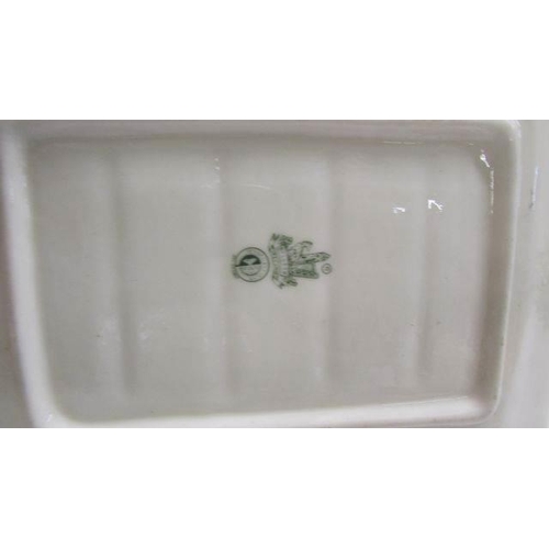 1242 - A Belleek butter dish in the form of a cottage together with a Belleek milk jug and sugar bowl.