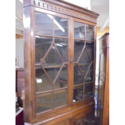 1413 - An oak astragal glazed corner cupboard with carved doors.