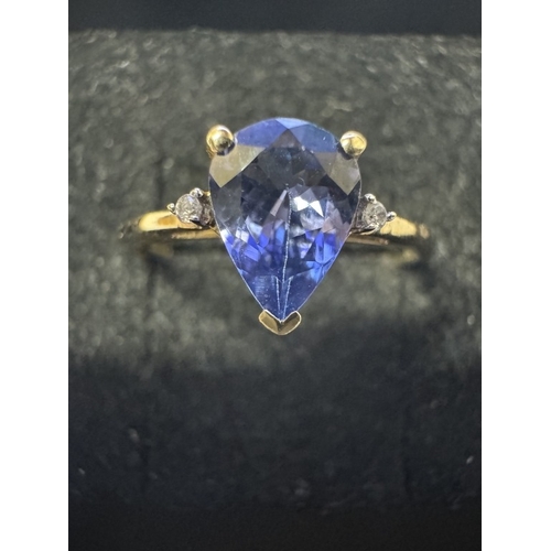 1011 - A yellow gold good colour tanzanite diamond ring. Size P