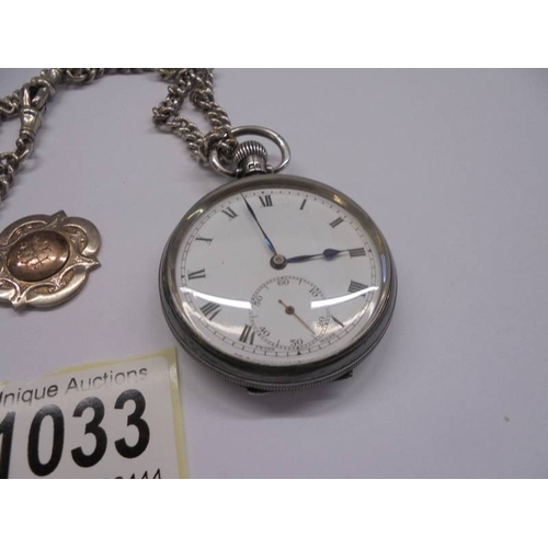 1033 - A good silver gent's pocket watch in working order on a silver Albert with two silver watch fobs.