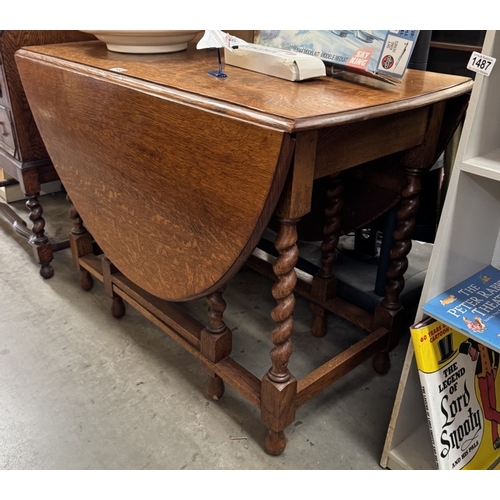 1492 - A 1930s golden oak gateleg dining table on barley twist legs