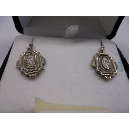 1043 - A pair of hand crafted silver earrings, (not marked but tested).