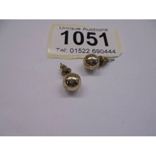 1051 - A pair of gold stud earrings, approximately 4.5 grams.