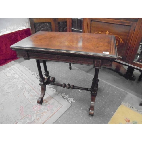 1558 - A Georgian inlaid walnut veneered fold over card table with beaded brass edging.