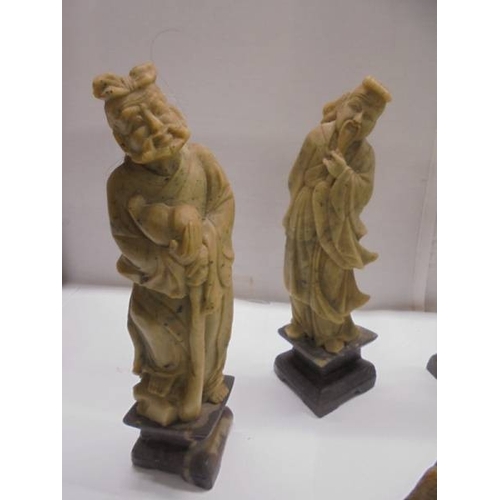 1648 - Eight circa 1900 carved soapstone Chinese figures and a carving of a mountain village.