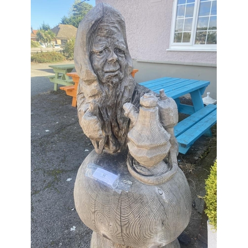 11 - A carved wooden figure of the Caterpillar from Alice in Wonderland. Height approximately 59 inches.