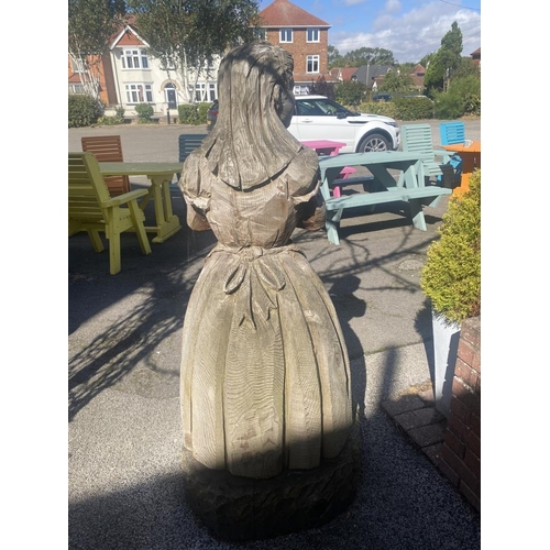 12 - A carved wooden figure of Alice from Alice in Wonderland. Approximately 60 inches high.
