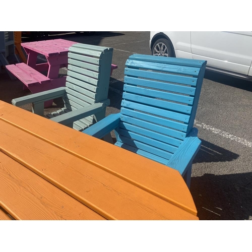 21 - A wooden garden table and four heavy wooden chairs. Painted different colours.