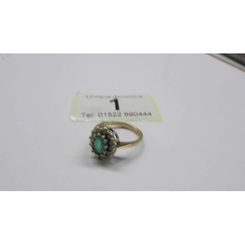 1 - A 9ct gold oval emerald ring surrounded by diamonds, size J. 2.7 grams.