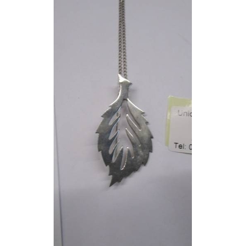 26 - A silver leaf pendant on a silver chain.