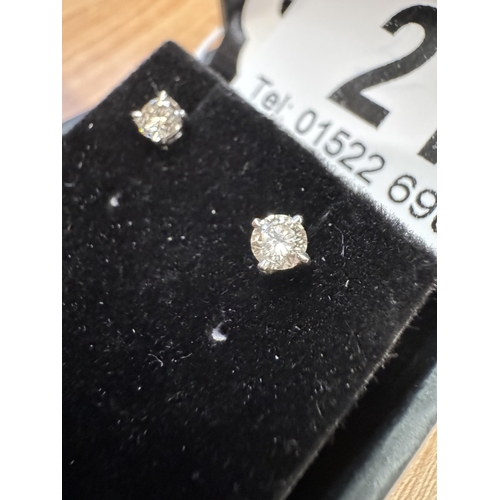 21 - A pair of 14ct white gold diamond stud earrings of 40 points total