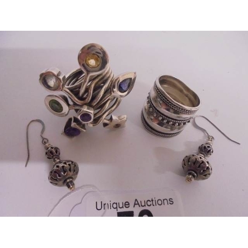 73 - Two heavy silver rings and a pair of silver earrings - large ring set with various stones, the other... 