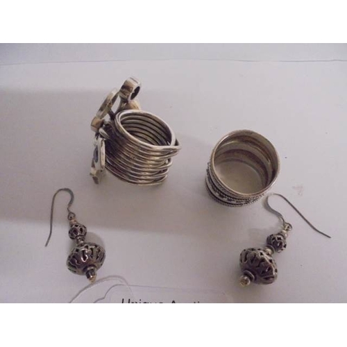 73 - Two heavy silver rings and a pair of silver earrings - large ring set with various stones, the other... 