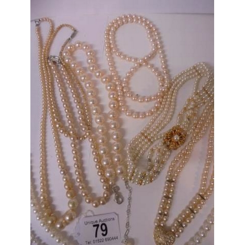 79 - Nine good faux pearl necklaces some with good fobs.