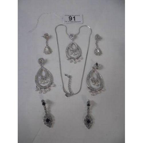 91 - A 20th century clear stone necklace with matching earrings and another two pairs of earrings.
