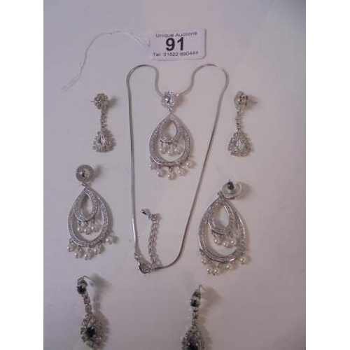 91 - A 20th century clear stone necklace with matching earrings and another two pairs of earrings.