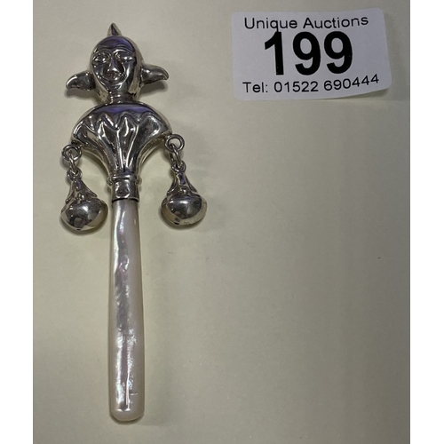 A silver mother of pearl handled babies rattle in the form of a court ...