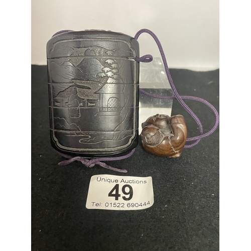 49 - A Japanese black lacquered inro with carved netsuke