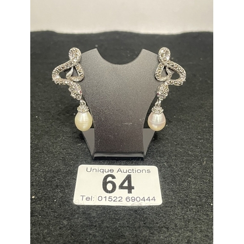 64 - A pair of silver and freshwater pearl earrings inset with rubies