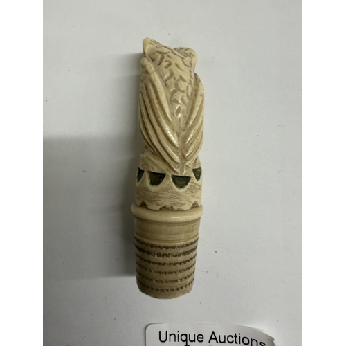 125 - A carved needlecase being an owl on thimble base