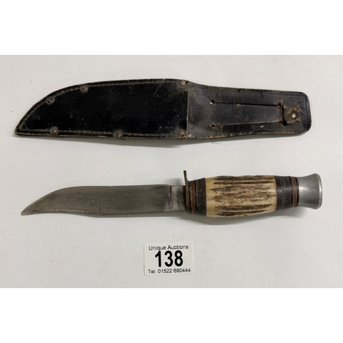 138 - A vintage hunting knife with leather sheath