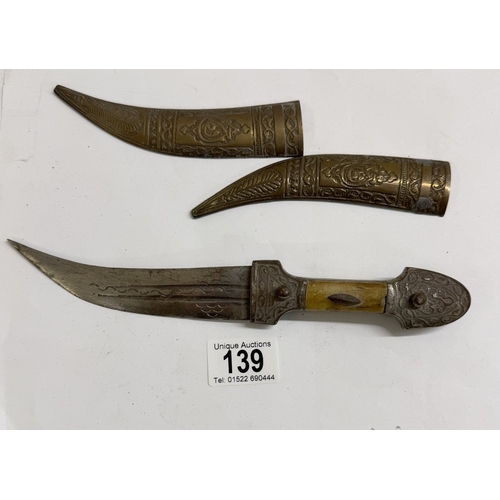 139 - A vintage oriental dagger / knife with decorative metal sheath
