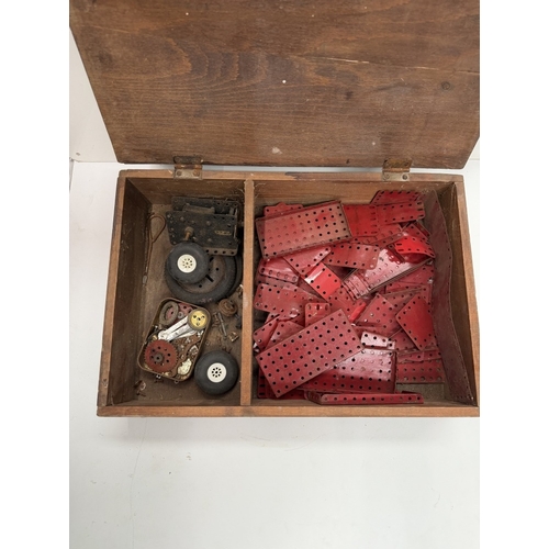789 - A wooden box of vintage Meccano parts including electric motor