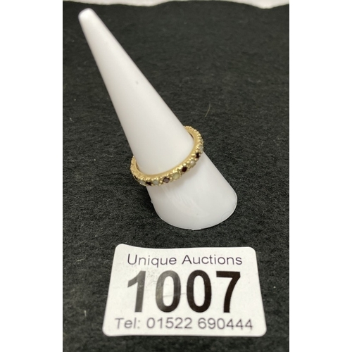 1007 - A 9ct gold eternity ring with red stone and opal settings (total weight 2.28g)