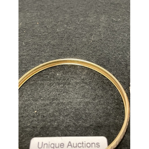 1028 - A 9ct bonded gold bangle (6.75g) and a silver surround cameo